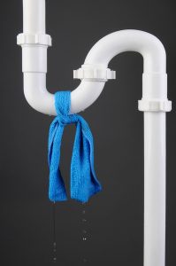 white pvc pipe with blue cloth tied around it