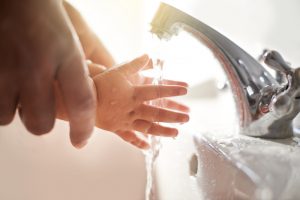 family-washing-hands-at-kitchen-sink