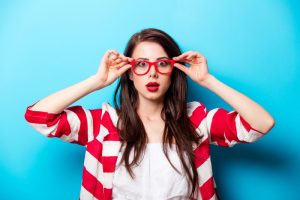 woman-looking-surprised-holding-glasses-on-face