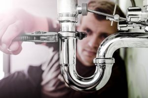 plumber-working-on-pipe-under-sink