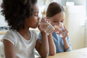 two-girls-drinking-water-from-glasses