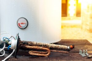 rusted-out-anode-rod-next-to-water-heater-tank
