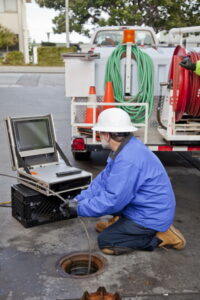 plumber-checking-web-cam-that-has-been-fed-down-pipe